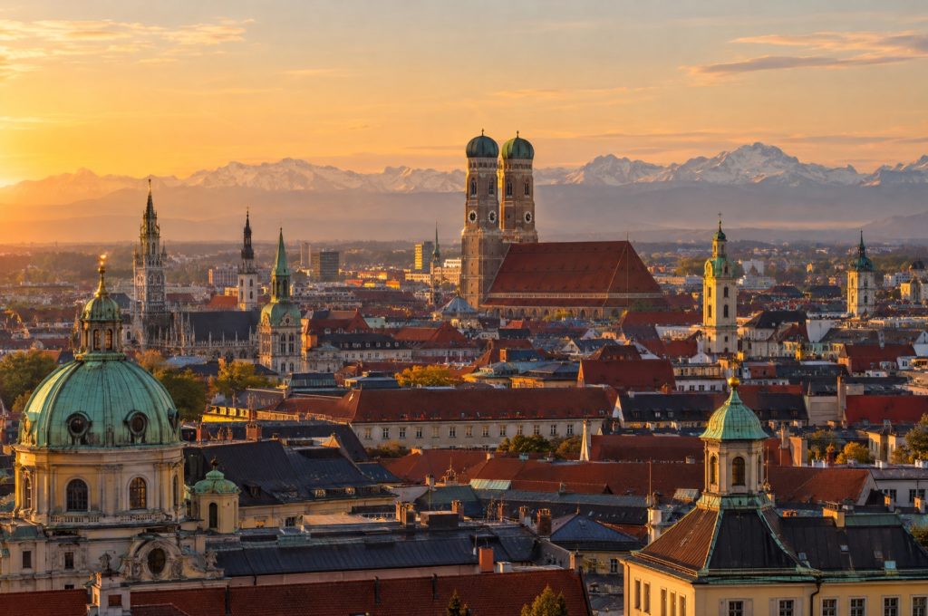 Münchner Dächer mit Frauenkirche und Alpen im Abendlicht